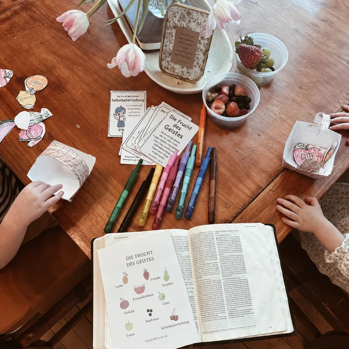 Kinderhände gestalten gemeinsam eine Aktivität am Tisch